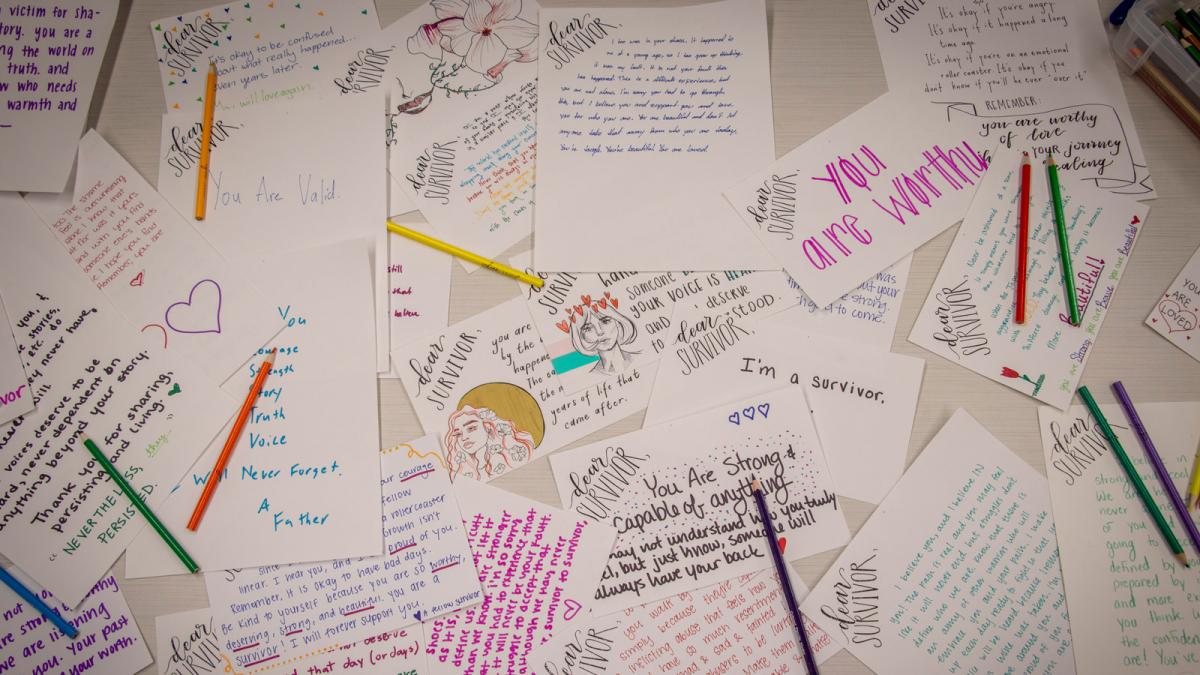 Supportive messages written on papers strewn across a desk